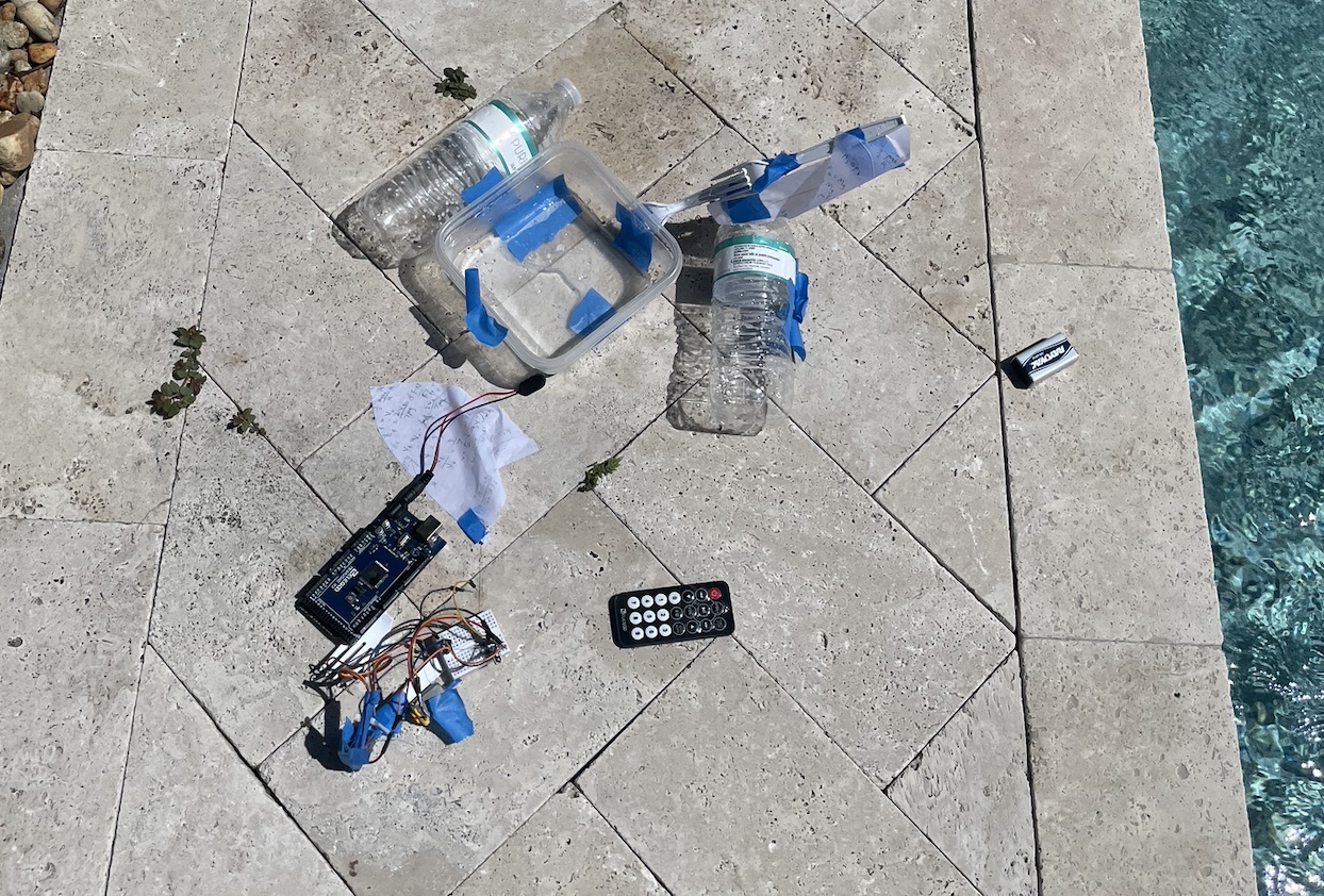Plastic parts and circuit components are laid on the ground next to a swimming pool